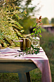 Coffee pot and vase on table in late-summer garden