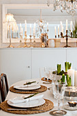 View across set dining table to tall sideboard with Christmas decorations in Scandinavian dining room