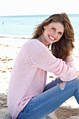 A young woman wearing a pink jumper