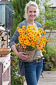 Woman carries basket of bear chamomiles