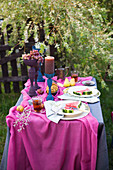 Festlich gedeckter Tisch in Blau und Violett im Garten