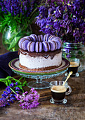 A festive blackberry cake with chocolate glaze and blue macaroons