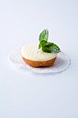 Ein Mini-Tartelett mit Schmand vor weißem Hintergrund