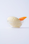 Apricot sorbet in a glass bowl against a white background