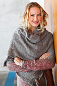 A blonde woman wearing a grey shawl