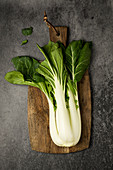 Bokchoy on a wooden plank at a black surface
