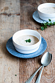 Coconutsoup in two white bowls witk coriander