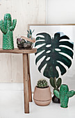 Arrangement of cacti and picture of cheese plant leaf