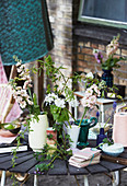 Bohemian-style flower arrangements in various vases on table