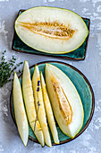 Aufgeschnittene Futuro-Melone auf türkisen Tellern