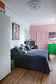 Pink wall and panelled door in bedroom of period building