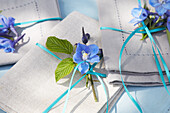 Leinenservietten mit blauen Blüten und Bändern