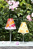 Candle lanterns made from paper lampshades on wine glasses