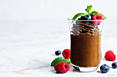 Roh veganer Schokoladen-Avocado-Pudding mit Beeren und Minze
