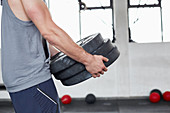 A muscular man carrying barbell weights