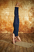 A man performing a headstand (yoga)