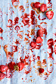 Erdbeeren und Saftreste auf Backpapier