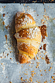 A puff pastry croissant on baking paper (seen from above)