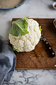 A cauliflower on a wooden board