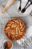 Apple pie with caramel sauce on a wire rack (seen from above)
