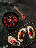 Baguette slices topped with cream cheese and mixed berries (seen from above)