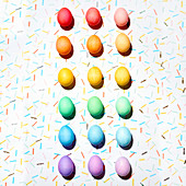 Colourful Easter eggs arranged in a colour gradient (top view)