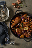 Chicken with potatoes, mushrooms and red onions in a roasting tin