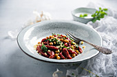 Beetroot orzo pasta with chickpeas, spinach and herb sauce (vegan)