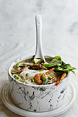 Bowl of Asian Noodle Soup with white ladle