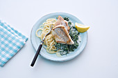 Rose fish on a bed of spinach with cream cheese and spaghetti