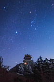 Orion in night sky above Buddhist temple