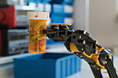 Robotic arm holding bottle of pills