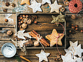 Gingerbread star shaped cookies, wooden angels, decorative stars, nuts and spices in wooden tray