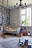 Wooden bed, gymnastic rings, soft toys and other toys in child's bedroom