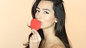 Woman kissing red heart shape