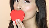 Woman kissing red heart shape