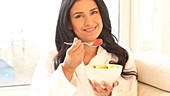 Woman eating bowl of fruit