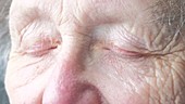 Elderly woman opening eyes