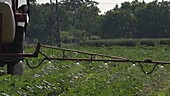 Tractor spraying pesticides on a field