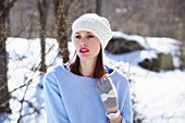A young woman wearing a white hat and a light blue jumper