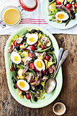Nizzasalat mit Römersalat, Kirschtomaten, Thunfisch, grünen Bohnen, schwarzen Oliven, Sardellen und hartgekochten Eiern