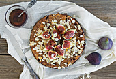 Fig pie with almond on a white tissue over the wooden surface