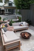 Sofa and fire bowl on terrace with mirrored wall