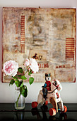 Nostalgischer Spielzeug-Reiter und rosafarbene Rosen vor einer Collage