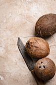 Drei frische Kokosnüsse mit Messer (Aufsicht)