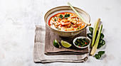 Tom Yam Kung (Spicy Thai seafood soup with shrimp, coconut milk and lemon grass) in bowl