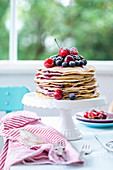 A pancake cake with fresh blackberries, raspberries, cherries and blueberries