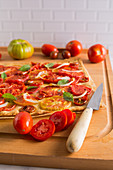 Tomato tart with onion and basil over puff pastry