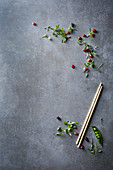 Pomegranate seeds, pea pods and chopsticks on a grey surface