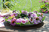 Pink wreath with dahlias, roses and Coneflower in a bowl of water